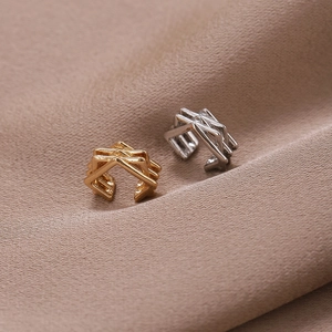 Elegantes Set aus gold- und silberfarbenen U-Ohrklemmen auf weichem Satinstoffhintergrund