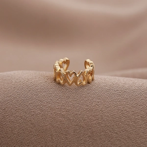 Minimalist gold heart-shaped hollow ring with elegant polished finish on fabric