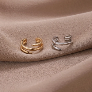 Detailansicht zweilagiger Spiral-Ohrklemmen in polierter Gold- und Silber-Ausführung