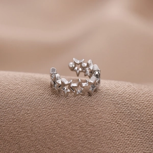 Minimalist silver U-shaped star ear cuff without piercing on brown textured fabric