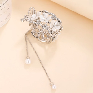 Vue détaillée d'une pince à cheveux fleurs et papillon avec strass et pompon perle