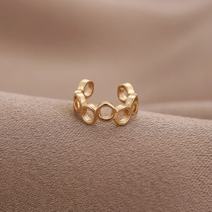 Minimalistische U-förmige unregelmäßige goldene Ohrmanschette auf braunem Seidenstoff