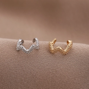 Detailansicht wellenförmiger Ohrmanschetten mit körniger Textur in Gold und Silber