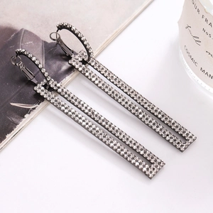 Detailed macro view of long rectangular dark gunmetal earrings with sparkling rhinestones