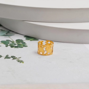 Bague ajustable dorée avec motifs d'étoiles et de lune sur présentoirs blancs