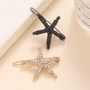 Vue détaillée macro de barrettes étoile de mer avec strass étincelants en or et noir
