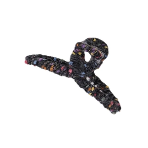 Detailed view of winter hair claw clip with colorful knitted yarn and soft tweed texture
