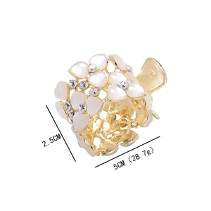 Dettaglio molletta per capelli a fiore dorato con cuori in madreperla e strass, 5cm