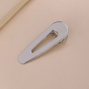 Detail of silver water-drop shaped metal hair clip with brushed stainless steel finish