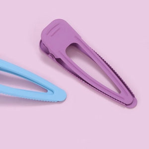 Matte macaron purple and blue triangle hair clips on soft pink background