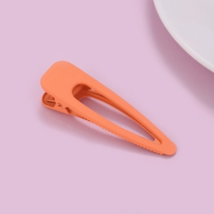 Close-up of orange matte finish hair clip with anti-slip sawtooth design