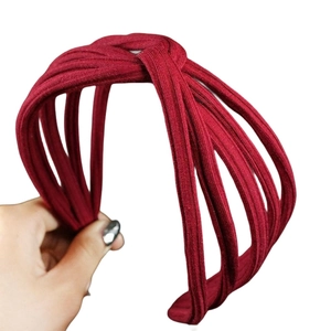 Deep burgundy ribbed knit wide headband featuring a stylish knotted overlapping design