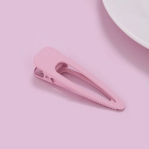 Detail view of pink matte duckbill hair clip with anti-slip teeth and metal spring