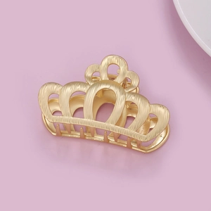 Pince à cheveux élégante en métal doré en forme de couronne évidée sur fond rose