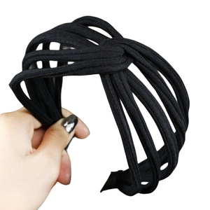 Detail of black woven headband featuring hollow structure and stylish central knot design