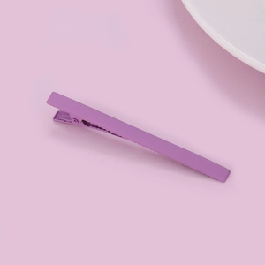 Matte purple alligator hair clip on pink background with minimalist metal design
