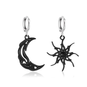 Detail of matte black sun and moon charms on silver polished earrings hoops