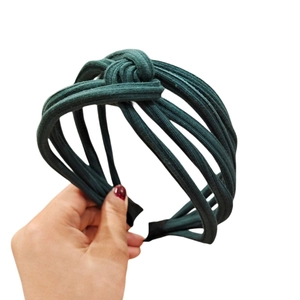 Detail view of dark green knotted headband with vintage layered fabric texture for women