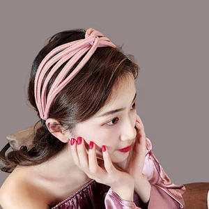 Pink knitted knotted headband for women with stylish twisted fabric design and soft texture