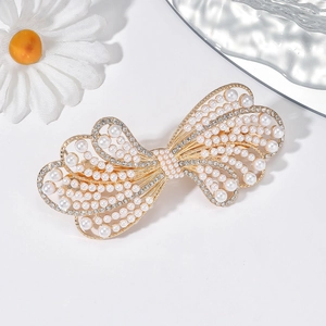 Détail de la pince à cheveux papillon dorée avec perles et strass scintillants