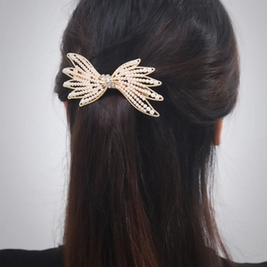 Barrette dorée élégante avec perles blanches et strass sur cheveux noirs lisses
