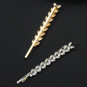 Golden wheat and silver leaf rhinestone hair clips on black leather background