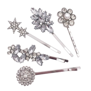Detail view of five silver alloy hair clips with sparkling rhinestones and a white pearl