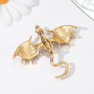 Back view of vintage golden dragon brooch showing hammered texture and pin safety clasp