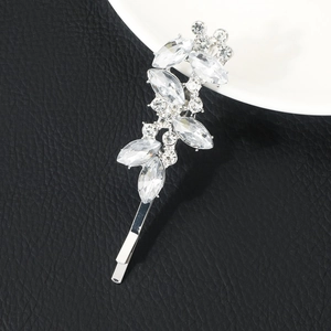 Detailed macro view of silver leaf hair clip with marquise-cut rhinestones on black leather