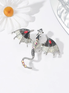 Macro detail of silver dragon brooch with enamel wings and vibrant crystal rhinestones