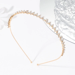 Détail d'un serre-tête doré orné de deux rangées de strass blancs scintillants