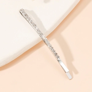 Détail de barrette à cheveux argentée sertie de strass brillants sur plaque de pierre
