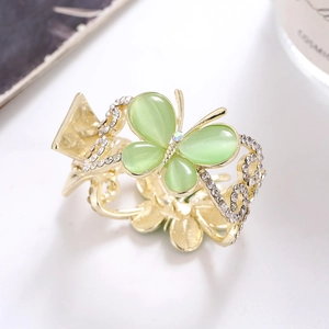 Eleganter goldener Schmetterling-Haarclip mit grünen Steinen und funkelnden Strasssteinen