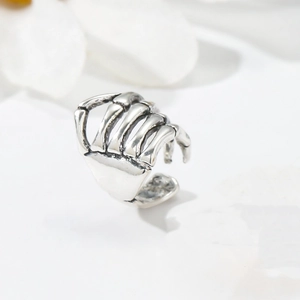 Macro view of silver skeleton hand cuff with vintage gothic bone texture detail