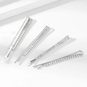 Dettaglio di un set di quattro fermagli per capelli color argento con strass lucidi