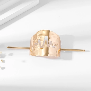 Macro detail of golden lightning hairpin set with hammered finish and heart rate cutout
