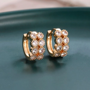 Detailed macro view of gold huggie earrings with double rows of sparkling zircon stones