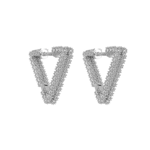 Detailed view of silver triangular earrings featuring textured grainy surface details