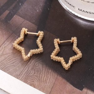 Retro golden star earrings with granular texture shown on artistic magazine backdrop