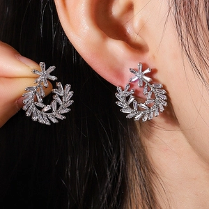 Elegant silver snowflake and wreath leaf drop earrings featuring sparkling baguette zircon stones