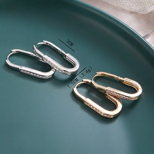 Detailed size view of copper oval earrings with inlaid diamonds measuring 3cm by 1.5cm