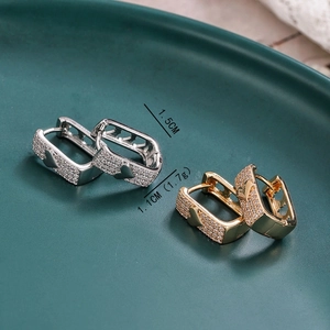 Detailed view of 1.5cm gold and silver heart earrings with sparkling zircon inlay
