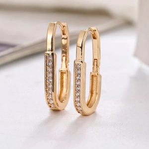 Chic U-shaped gold earrings for women with paved cubic zirconia stones on marble