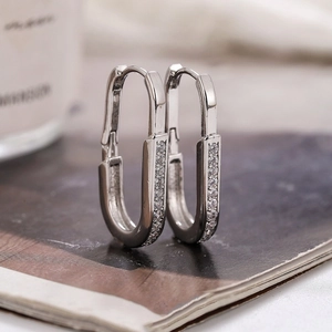 Silver U-shaped hoop earrings with micro-pave cubic zirconia on polished metal surface