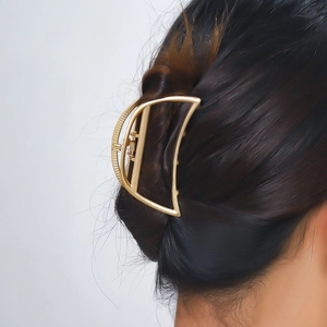 Dettaglio di un grande fermaglio per capelli dorato a mezzaluna su uno chignon