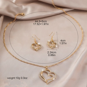 Vintage gold-finish hollow heart jewelry set with necklace and earrings on silk