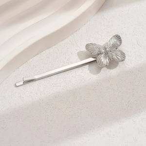 Barrette papillon argentée élégante avec détails métalliques sur un support épuré
