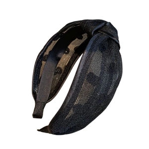 Elegant black mesh headband with polka dots and twisted knot design on white background