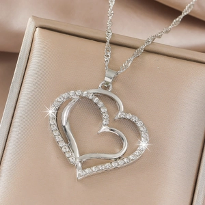 Detailed close-up of layered heart pendant with sparkling rhinestones on champagne silk