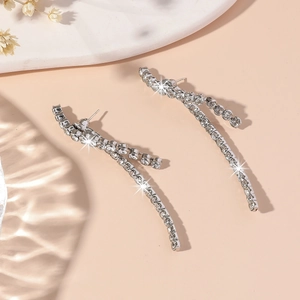 Detail view of silver tassel earrings with sparkling rhinestones in soft lighting